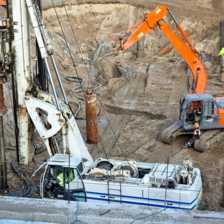 Closeup of heavy excavators and construction machines working on building site.